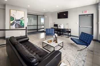 a living room with a black couch and blue chairs
